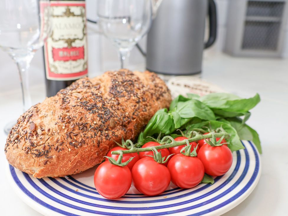 A plate with bread, tomatoes, and basil in a kitchen at Greenfingers in Whitby