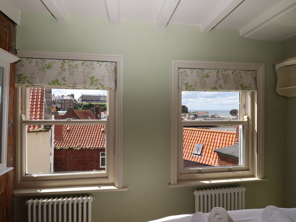 A bedroom with windows showing a view at Greenfingers in Whitby