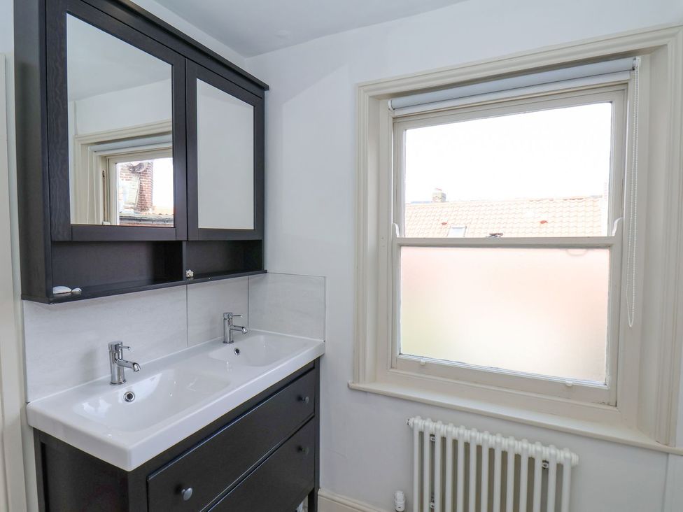 A bathroom with double sink and mirror at Greenfingers in Whitby