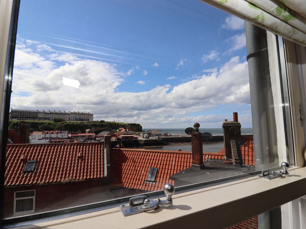 A view from a window showing rooftops and the ocean at Greenfingers in Whitby