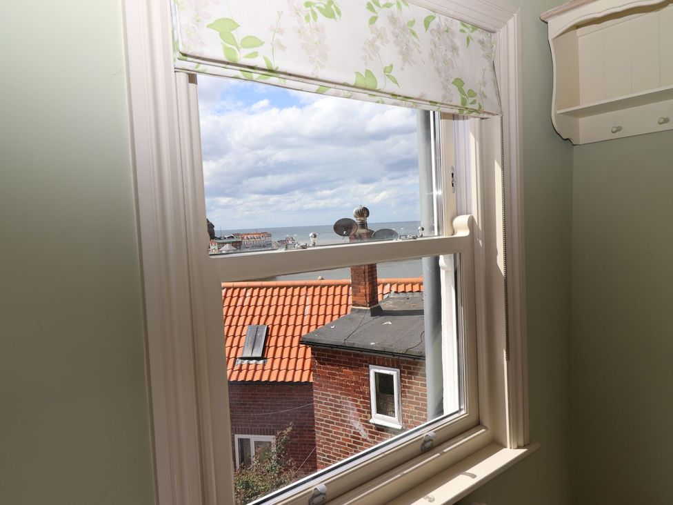 A window with a view of rooftops and sea at Greenfingers in Whitby