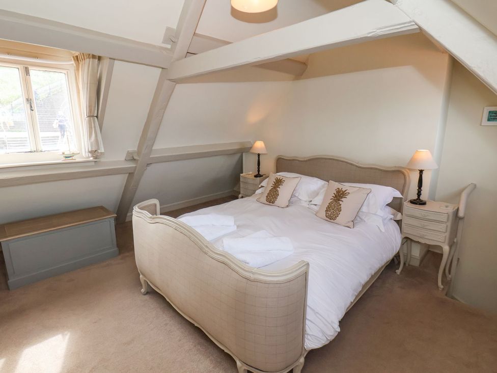 A bedroom with a bed and nightstands at Greenfingers, Whitby