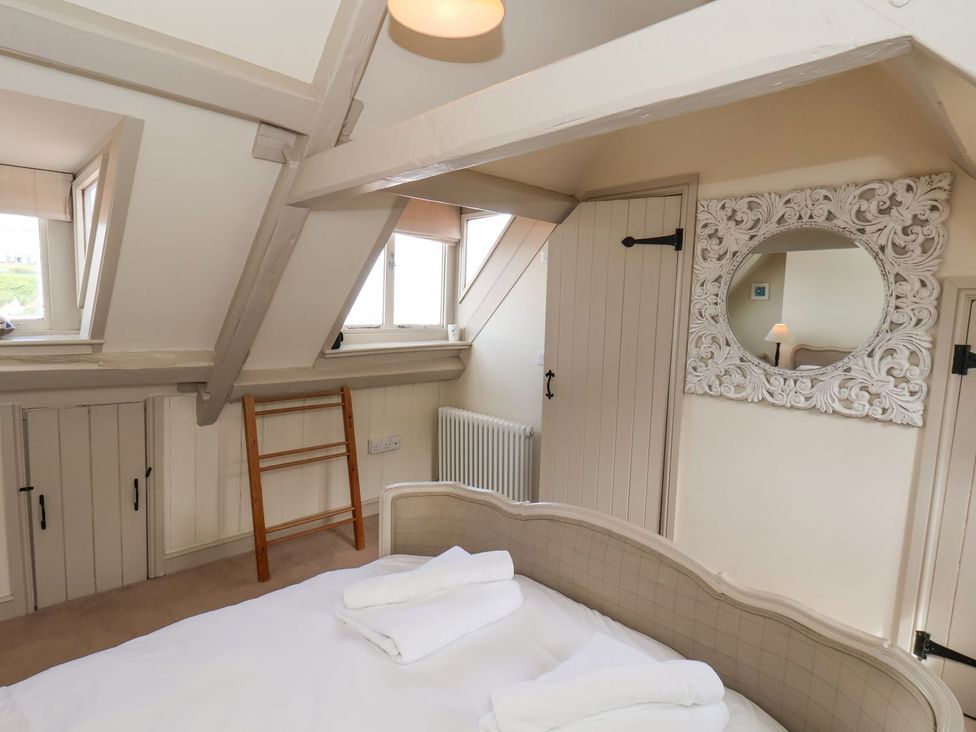 A bedroom with a bed and mirror at Greenfingers in Whitby