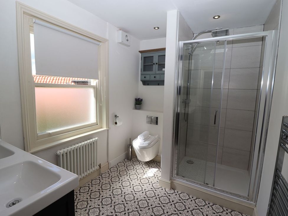A bathroom with a shower, toilet, and sink at Greenfingers in Whitby