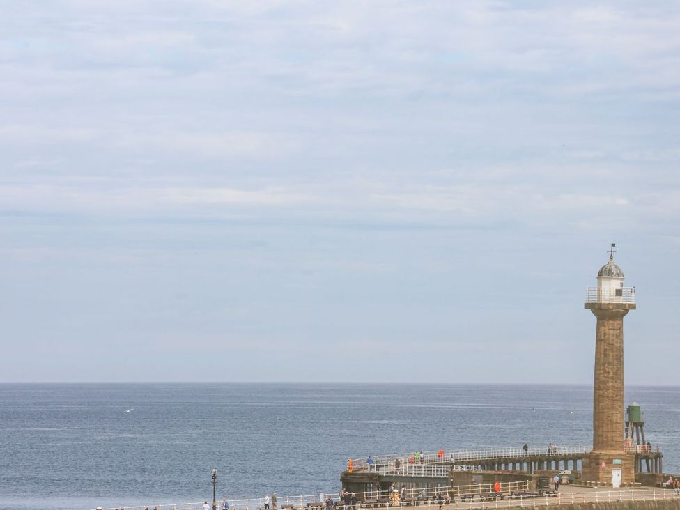 A lighthouse on a pier beside the ocean at Greenfingers in Whitby