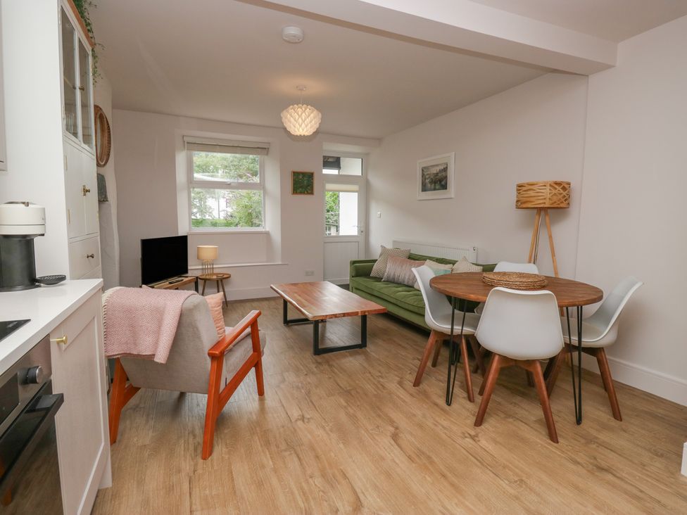 A living room with a sofa and dining area at Wansfell Nook in Ambleside