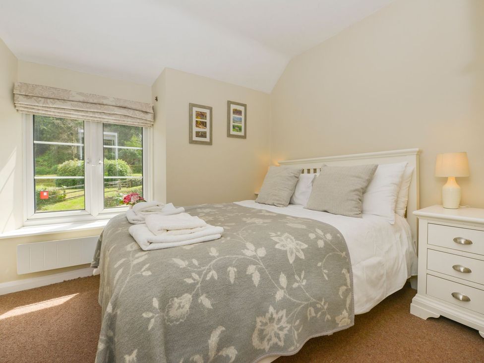 A bedroom with a bed and window at Woodedge in Minehead