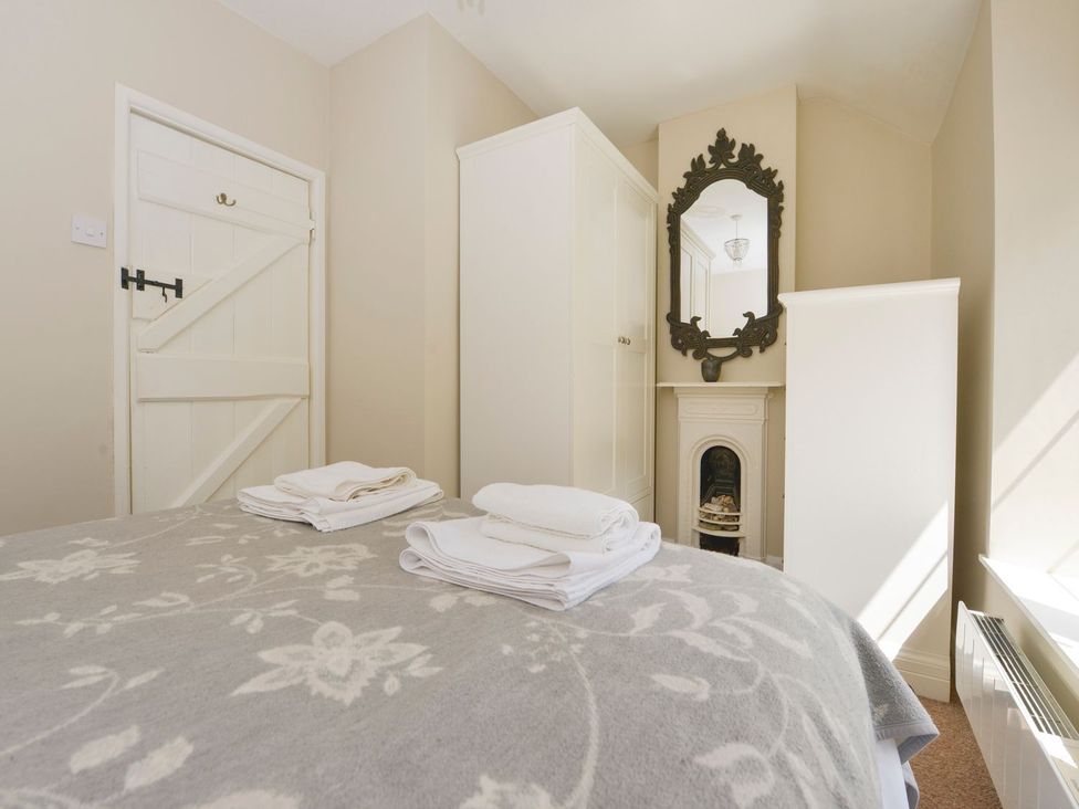 A bedroom with a bed and towels at Woodedge in Minehead
