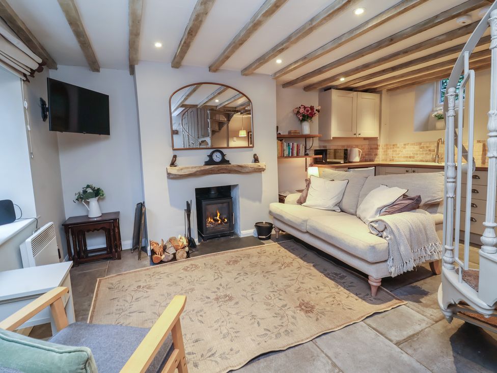 A living room with a fireplace and sofa at Woodedge in Porlock
