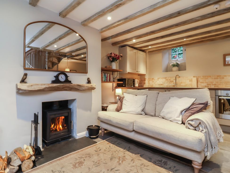 A living room with a fireplace and a sofa at Woodedge in Porlock