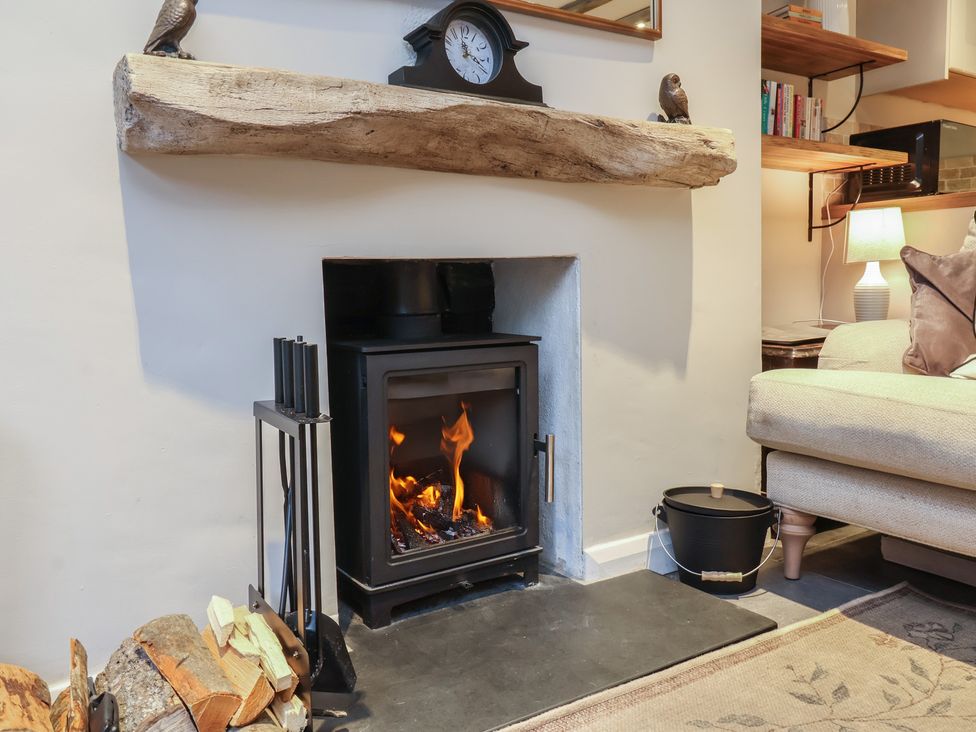 A living room with a fireplace and sofa at Woodedge in Porlock