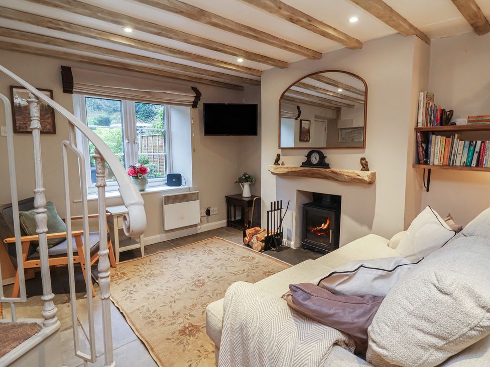 A living room with a sofa and a fireplace at Woodedge in Porlock