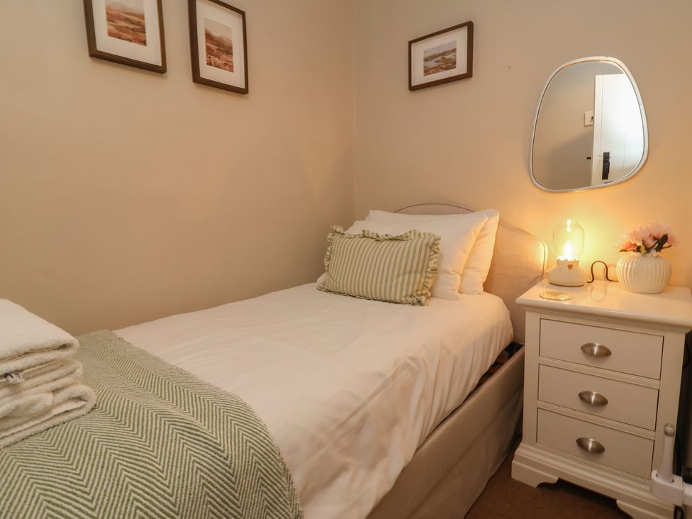 A bedroom with a single bed and bedside table at Woodedge in Porlock