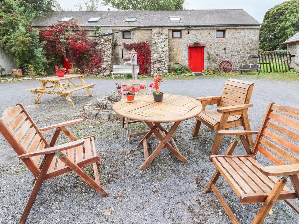 An outdoor seating area with a round table and wooden chairs at null in null