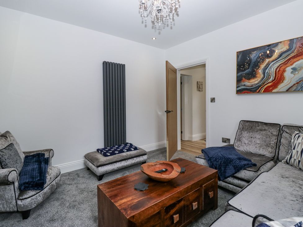 A living room with a coffee table and two sofas at Holy Trinity Cottage in Millom