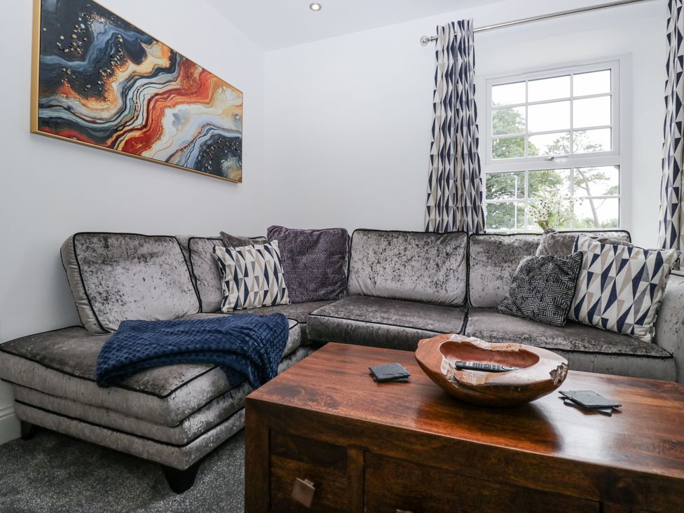 A living room with a sofa and coffee table at Holy Trinity Cottage in Millom