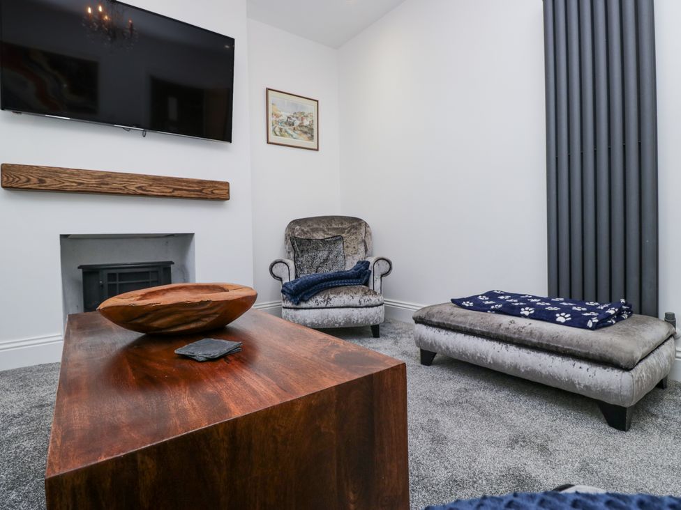A living room with a sofa and television at Holy Trinity Cottage in Millom