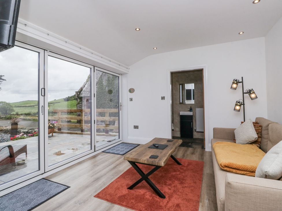A snug with a sofa and coffee table at Holy Trinity Cottage in Millom