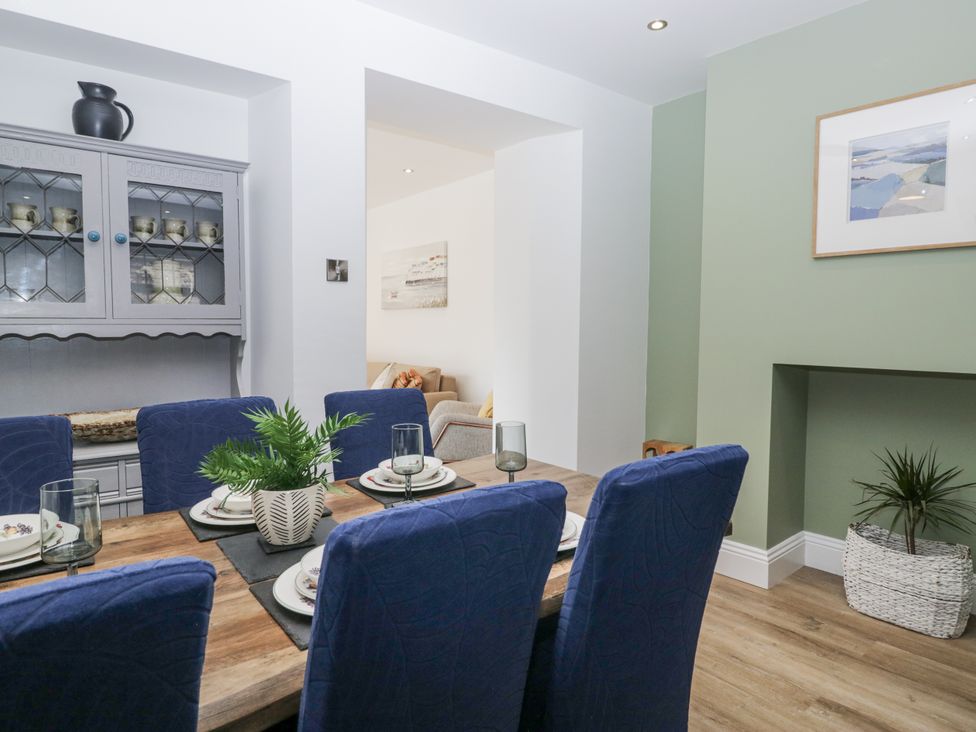 A dining room with a table set for a meal at Holy Trinity Cottage in Millom