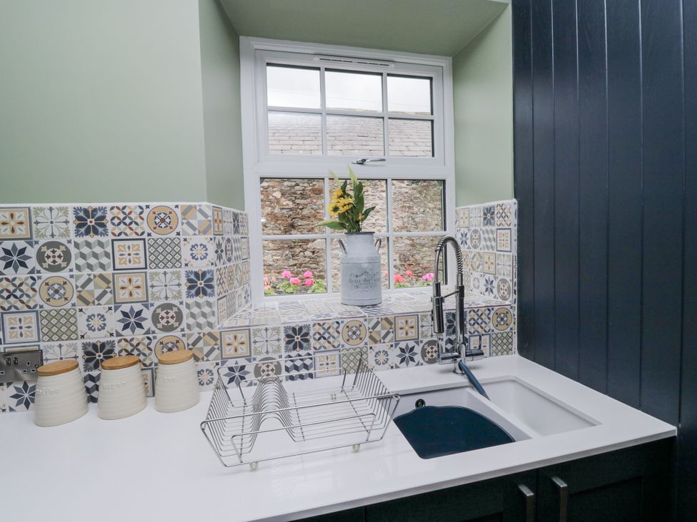 A kitchen with a sink and dish rack at Holy Trinity Cottage in Millom