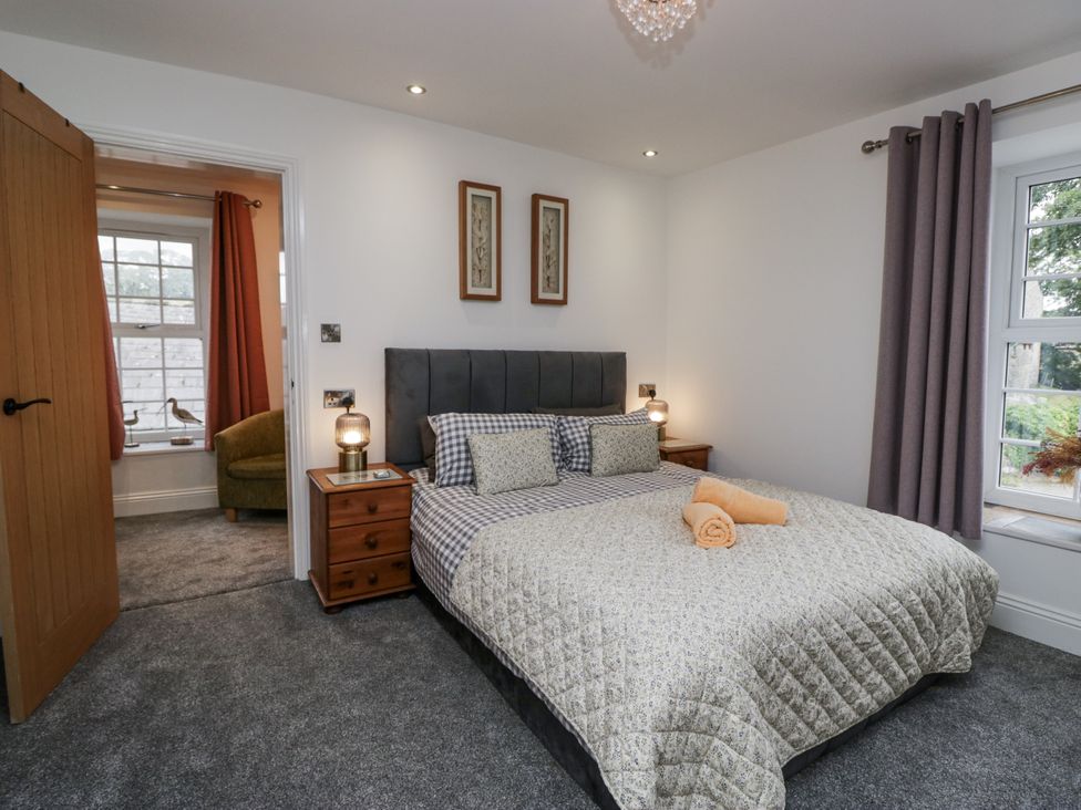 A bedroom with a bed and window at Holy Trinity Cottage in Millom