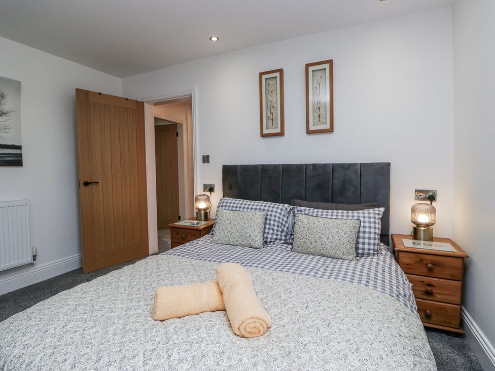 A bedroom with a bed and bedside tables at Holy Trinity Cottage in Millom