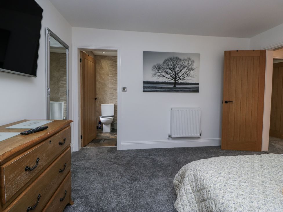 A bedroom with a bed and a television at Holy Trinity Cottage in Millom