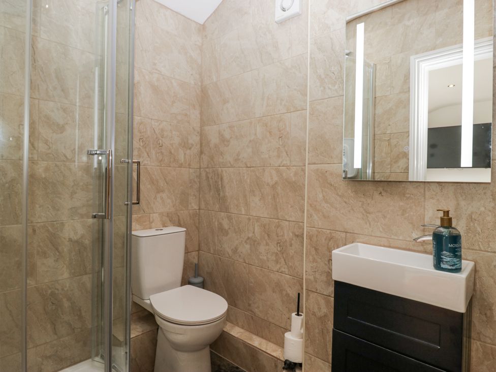 A bathroom with a shower, toilet, and sink at Holy Trinity Cottage in Millom