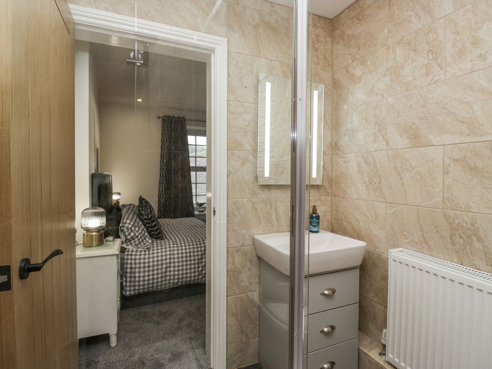 A bathroom featuring a shower, sink, and mirror at Holy Trinity Cottage in Millom