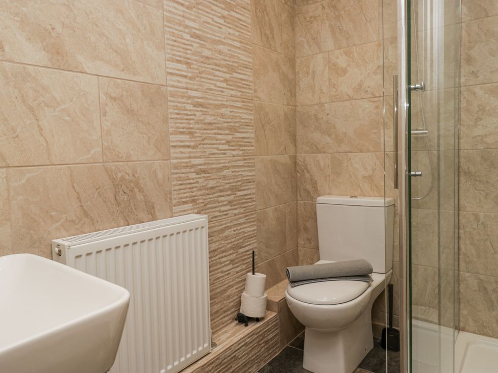 A bathroom with a shower and toilet at Holy Trinity Cottage in Millom