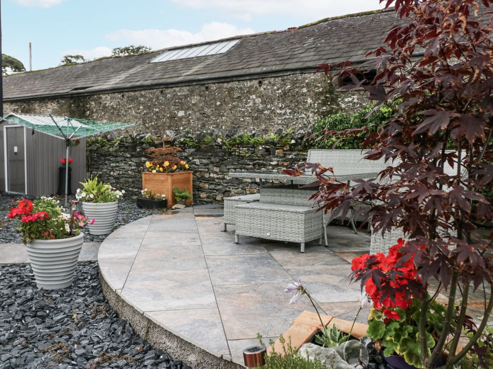 A garden with furniture and potted plants at Holy Trinity Cottage in Millom