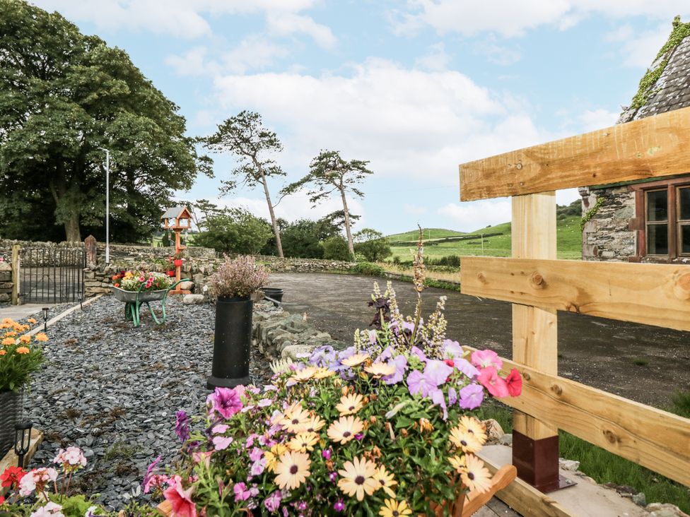 An outdoor area with flower pots and gravel at Holy Trinity Cottage in Millom