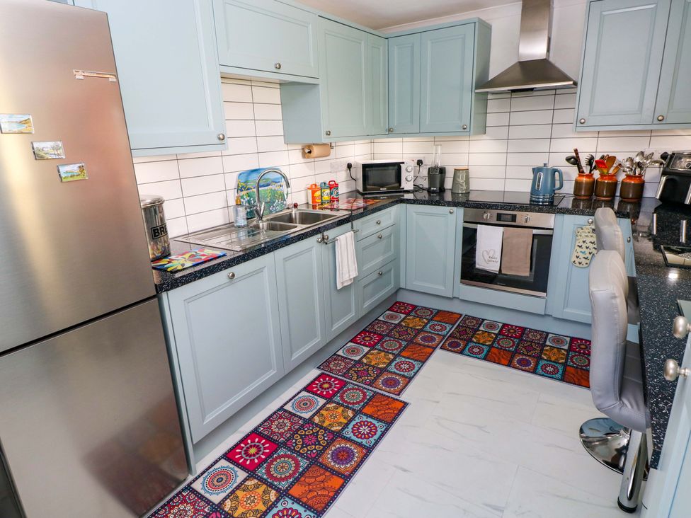 A kitchen with appliances and a countertop at No.51 Llanteg Park in Amroth