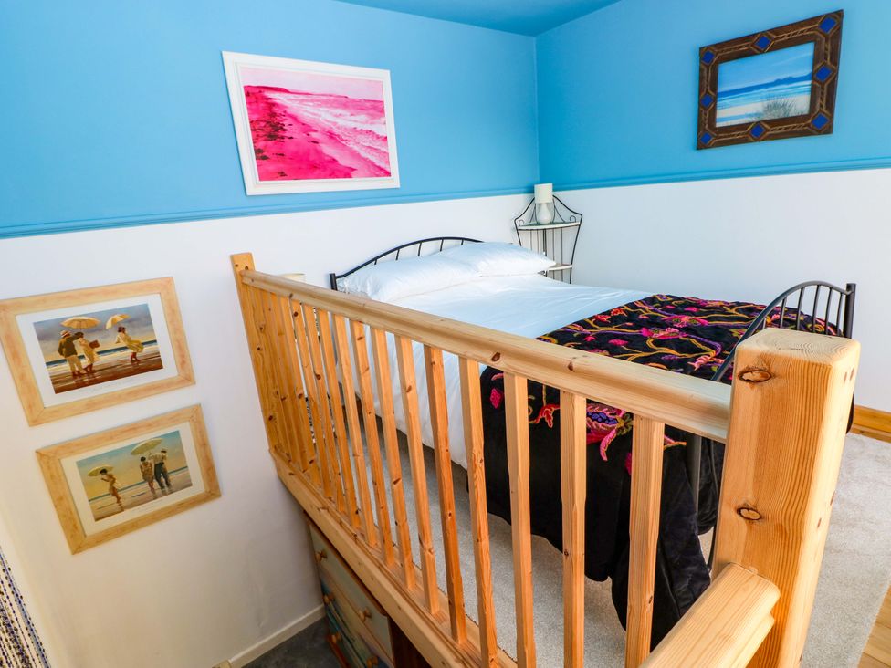 A bedroom with a bed and pictures on the wall at No.51 Llanteg Park Amroth