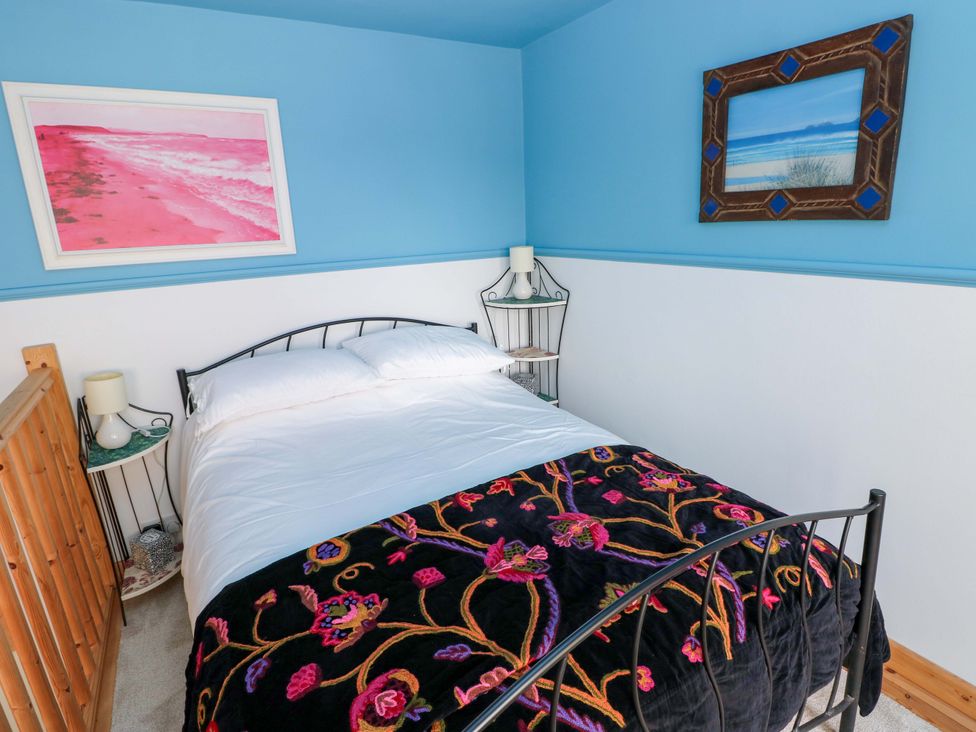 A bedroom with a bed and bedside table at No.51 Llanteg Park in Amroth