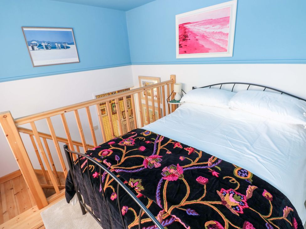 A bedroom with a bed and decorative wall art at No.51 Llanteg Park in Amroth