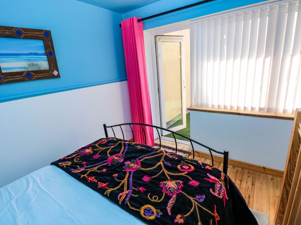 A bedroom with a bed adorned with a blanket at No.51 Llanteg Park Amroth