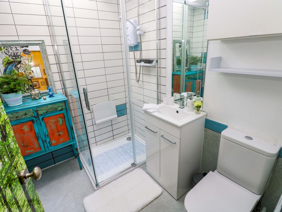 A bathroom with a shower, toilet, and sink at No.51 Llanteg Park in Amroth