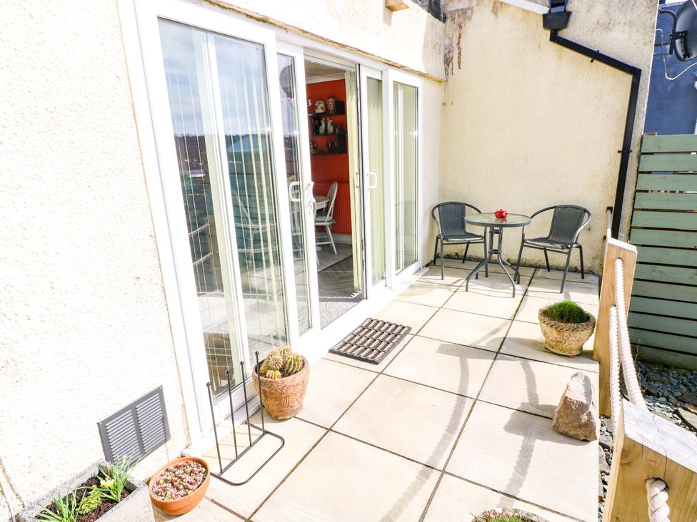 An outdoor patio area with a table and chairs at No.51 Llanteg Park in Amroth