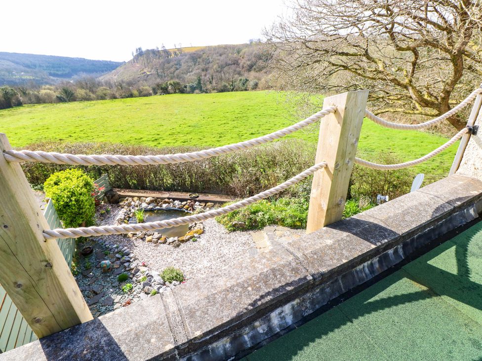 A garden view with a pond and grass at No.51 Llanteg Park Amroth