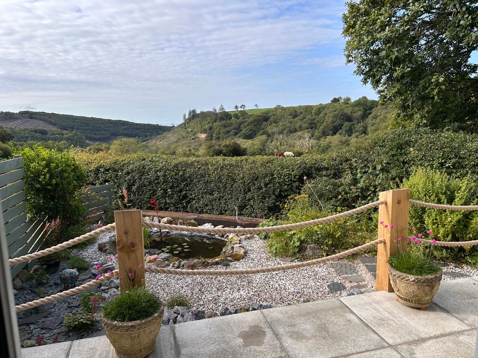 A garden with a pond and flowers at No.51 Llanteg Park in Amroth