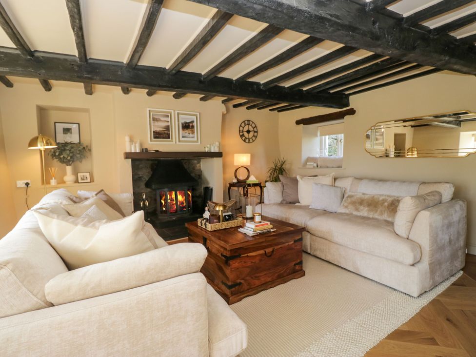 A living room with a fireplace and two sofas at Barn Howe Lyth near Levens