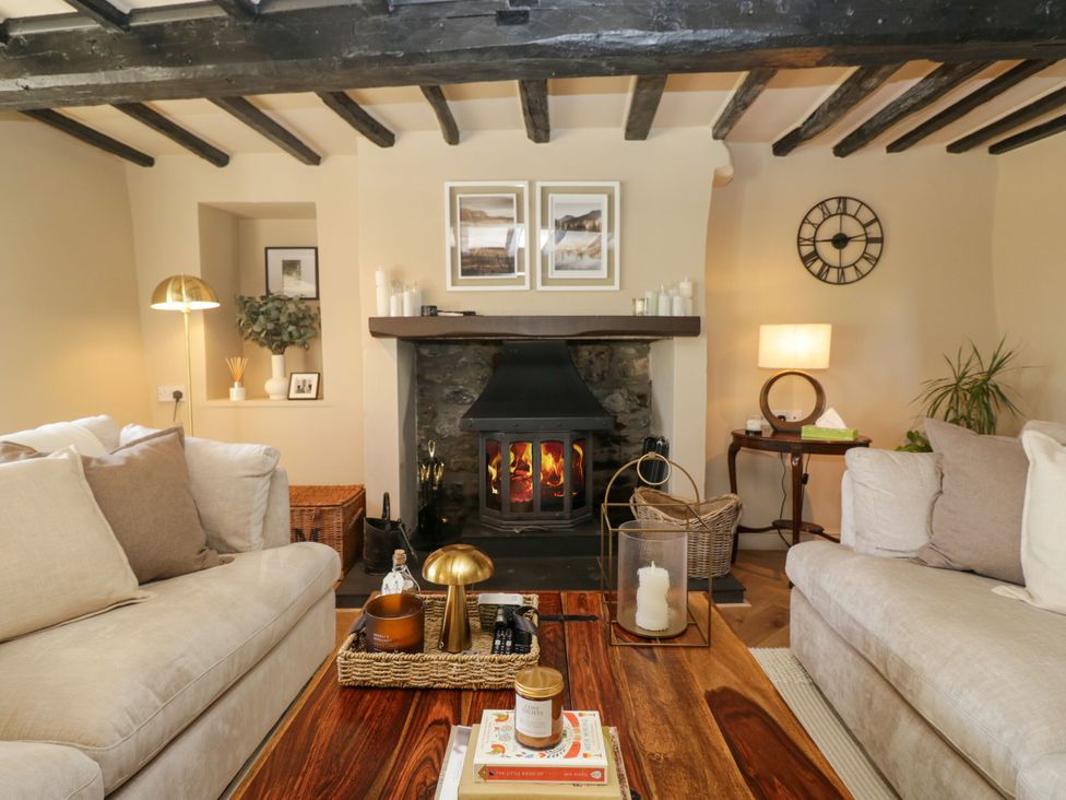 A living room with a fireplace and seating at Barn Howe Lyth near Levens