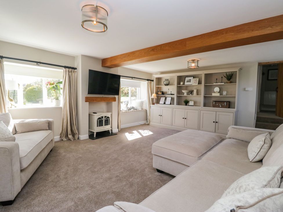 A living room with a sofa and shelving at Barn Howe Lyth near Levens