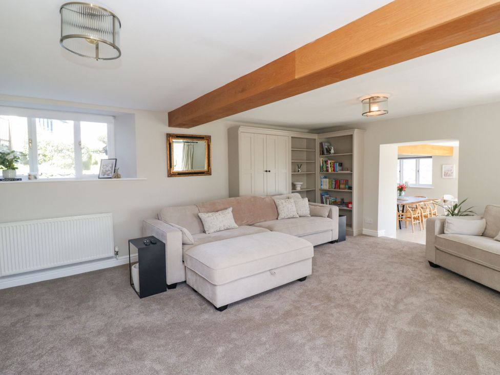 A living room with a sofa and bookshelf at Barn Howe in Lyth near Levens