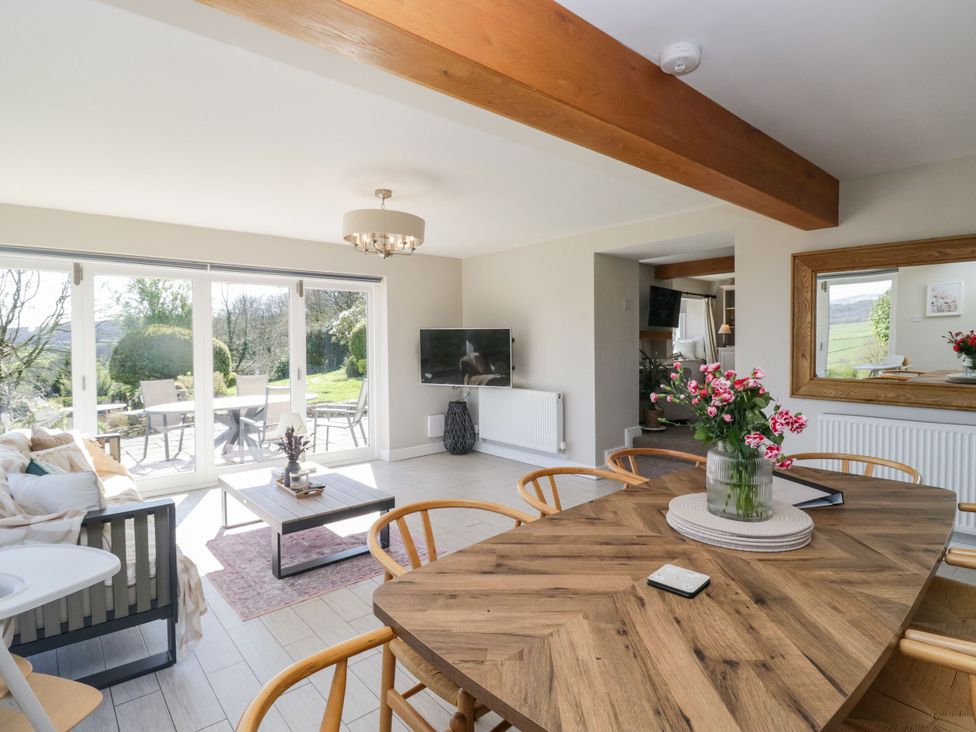 A living room with a dining area and sliding doors at Barn Howe in Lyth near Levens