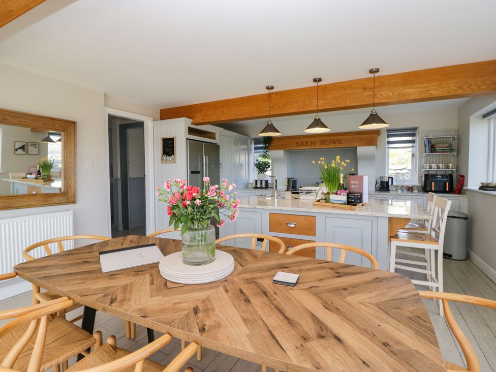 A kitchen with a dining table and chairs at Barn Howe in Lyth near Levens