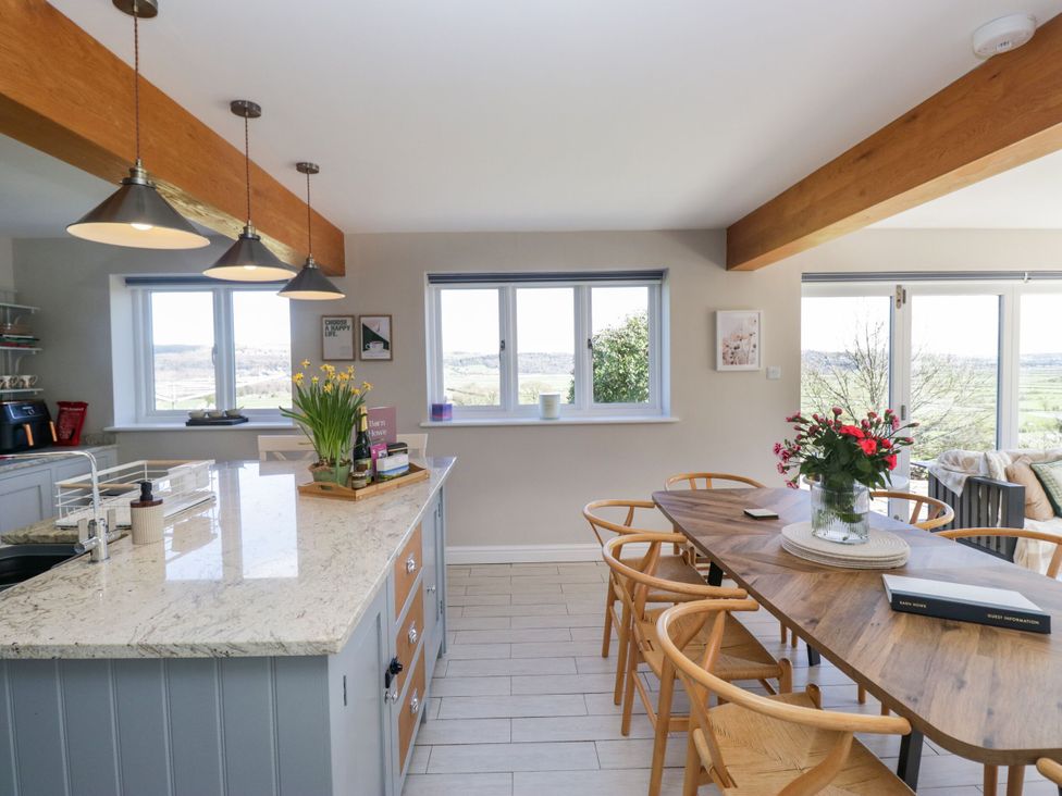 A kitchen with a large island and dining table at Barn Howe in Lyth near Levens