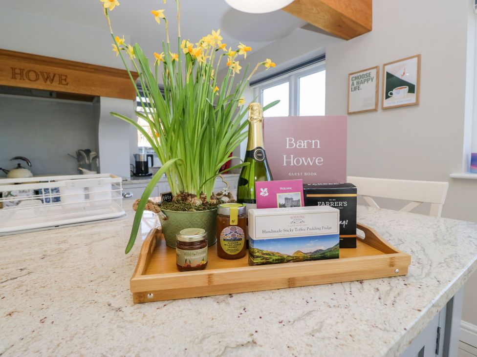 A tray with a flower pot, champagne, and a guest book at Barn Howe in Lyth near Levens