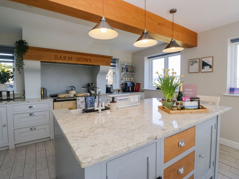 A kitchen with a countertop island and appliances at Barn Howe in Lyth near Levens